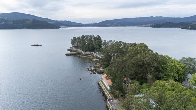 Aerial view of Illa de San Simon featuring historic stone walls and lush green trees surrounded by the calm waters of the estuary Pontevedra, Pontevedra, Spain.