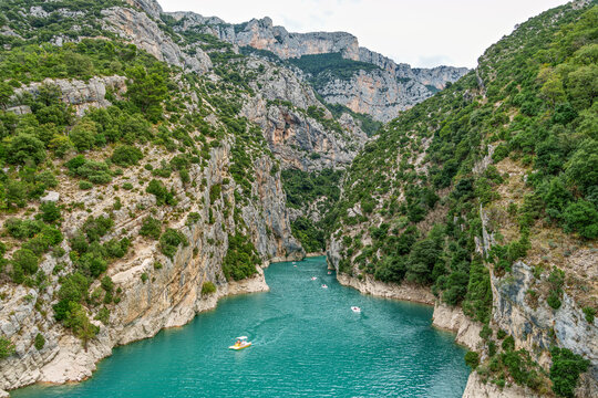 Tourists enjoying turquoise waters of the Verdon River in France, paddling pedal boats and kayaks on a sunny day