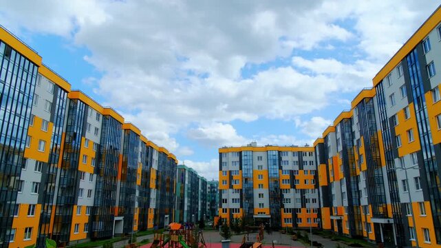 Colorful apartment complex with landscaped surroundings. Energetic scene showcasing multilevel housing with garden features