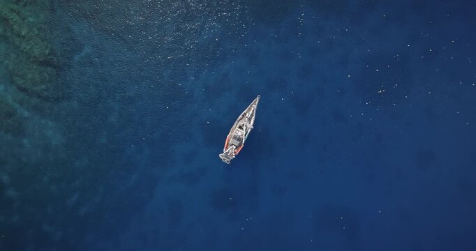 Sailing yacht navigating tropical blue ocean water of Tegua in Torres Islands archipelago, showcasing tourist boat near coral reef, adventure and exploring remote island destinations. Aerial top down
