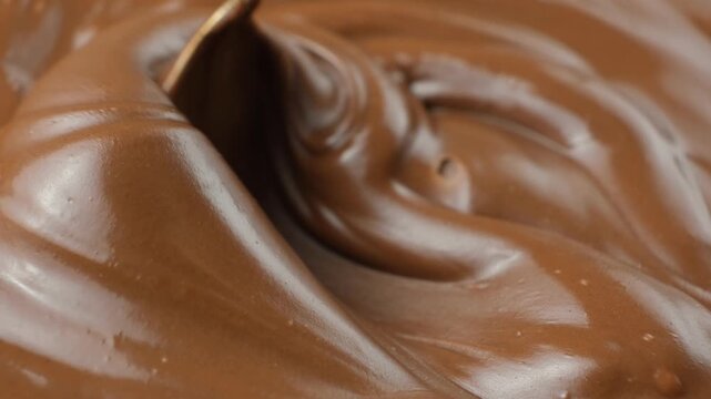 Stirring chocolate spread with a spoon, macro texture
