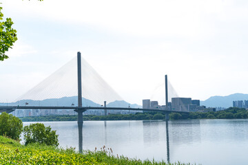 Obraz premium Guri-Topyeong Bridge and a peaceful riverside walking path along the Han River in Guri, South Korea