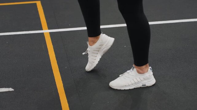 Indoor badminton court closeup feet executing precise placement, athlete practices measured toe and heel work on marked lines, slow controlled cadence emphasizes technique, balance and timing