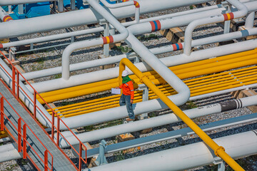Male worker inspection at steel long pipes and pipe elbow in station oil factory during refinery valve of visual check record pipeline tank oil © chitsanupong