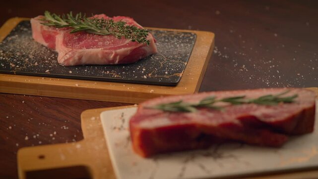 fresh cut raw steak with rosemary on dinner table