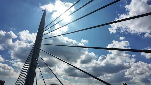 Modern cable-stayed Golden Horn Metro Bridge pylon and steel cables against blue sky with clouds in Istanbul, Turkey.