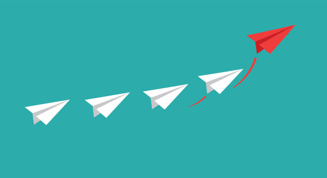 Single red paper plane breaking away from a line of white ones and flying upwards in a completely new direction.