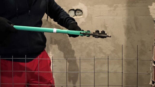 Heavy-duty bolt cutters cutting through a metal wire mesh in an industrial environment. Large scissors for steel. Hands equipment. Handle work is on construction site. High quality 4k footage.