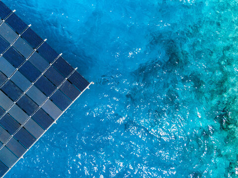Aerial view of the SolarSea floating solar power plant by Swimsol on clear turquoise tropical water in Dharavandhoo, Baa Atoll, Maldives.