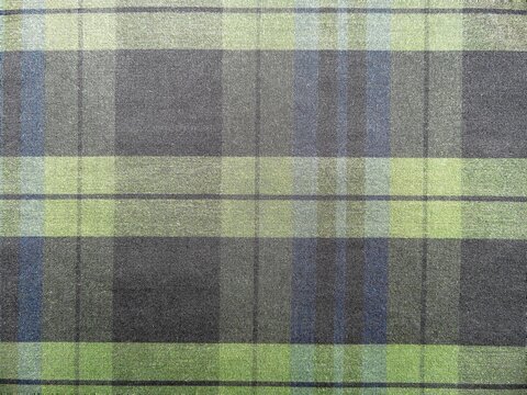 Classic blue and green plaid fabric texture. Tartan checkered pattern background on woven textile material.