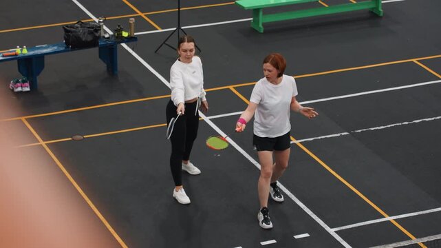 Indoor badminton skills. Training session for badminton techniques. Coach demonstrates proper grip and footwork methods. Indoor court badminton training focusing on grip and footwork skills