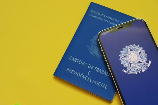 Salvador, Brazil - May 11, 2026: Brazilian Work Card (CTPS - Carteira de Trabalho e Previdencia Social) over a green and yellow background. Concept of labor rights, employment in Brazil. 