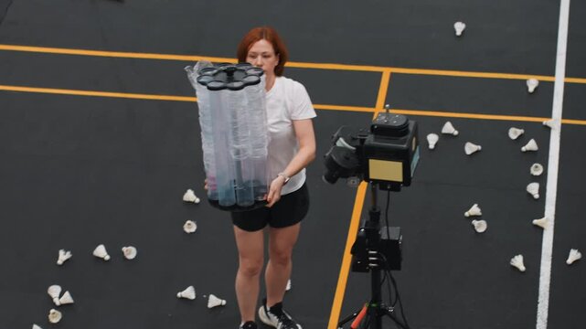 Preparing equipment for match. Athlete setting up for rigorous badminton training drills. Sports professional organizing shuttlecocks and adjusting equipment prior to intense practice session