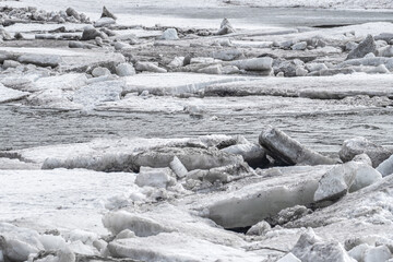 Melting river ice and spring ice drift on northern river with cold water and drifting ice floes, natural landscape with harsh atmosphere, concept of climate change and global warming © Vladimir Razgulyaev