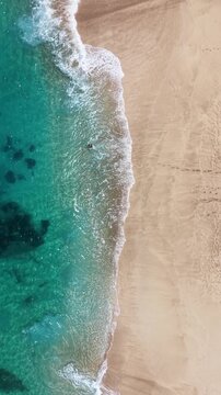 Shot looking straight down at the waves along the beach on the northshore island of Oahu in Hawaii.