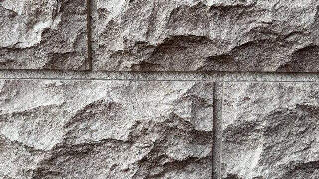 Close-up textured stone facade panels, dark brown natural stone with chiseled rough surface, modular block layout with visible