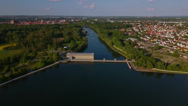 The Ingolstadt dam and reservoir appear in a clear summer panorama with water surfaces, natural islands and the Laufwasserkraftwerk Ingolstadt set in Upper Bavaria green landscape.