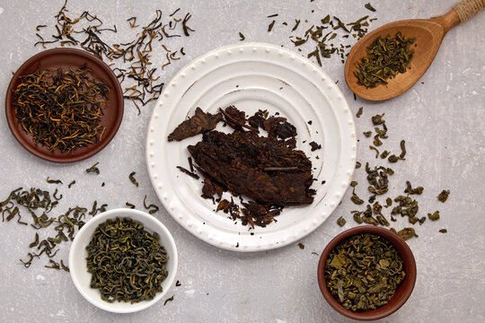 tea leaves of different varieties dried and fermented on a gray concrete table with a top view