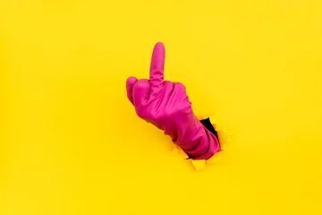 Hand in pink glove showing middle finger gesture © GVS