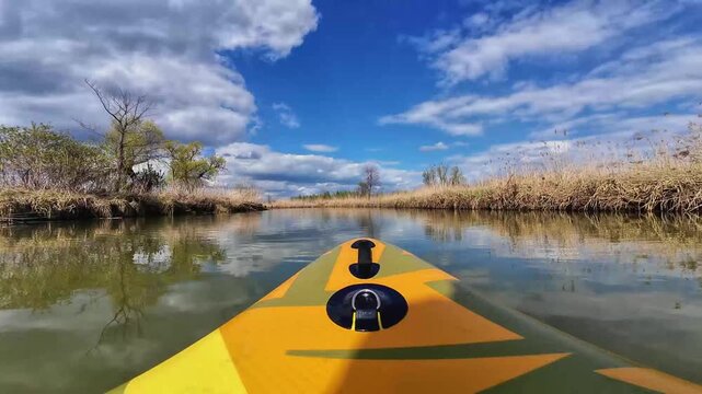 Kayak Crossing Marsh Under Storm Clouds, Yellow Bow Cuts Choppy Water Near Tall Reeds, Dramatic Lighting And Windswept Sky Create Moody Tension And Thrilling Atmosphere