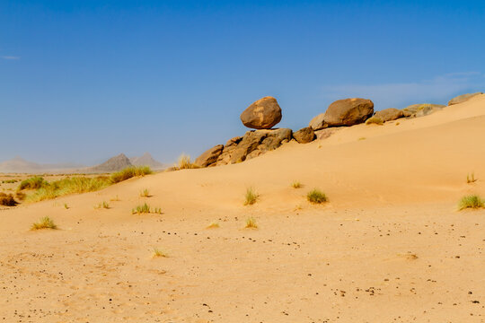 Sahara landscape. Rock formations with large, round boulders on a dune. Tassili n'Ajjer National Park, Algeria, Africa
