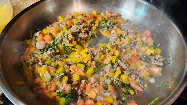Colorful vegetable stir fry cooking in pan on stovetop kitchen scene