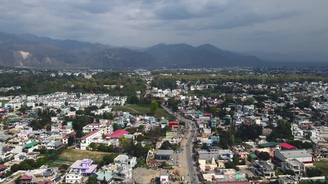 An aerial view of Dehradun, an Indian city, during sunrise or sunset, with cloudy weather and rows of residential houses.