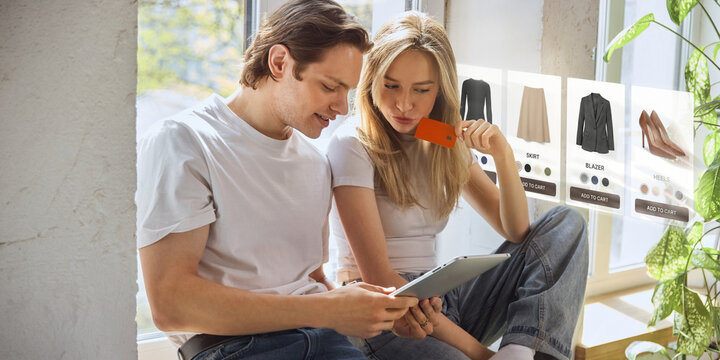 Couple shopping for clothes online with tablet and floating fashion product cards at home. Concept of fashion ecommerce, mobile shopping, personalized offers, digital storefront and retail app design.