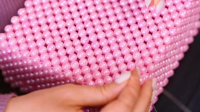 Close-up pink beadwork box hand crafting detailed pearl beads glossy surface delicate design