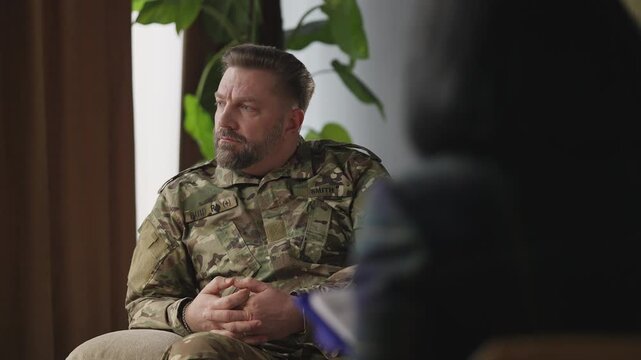 Sad military man listening to psychologist, coping with ptsd during therapy