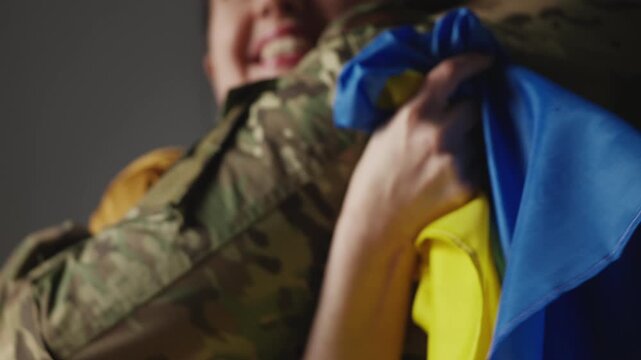 Smiling Ukrainian woman embracing her soldier husband coming back home from war