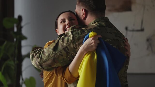 Excited Ukrainian wife hugging military husband coming back home, family reunion