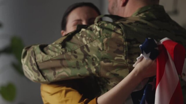 Glad American wife hugging her military husband coming back home from service