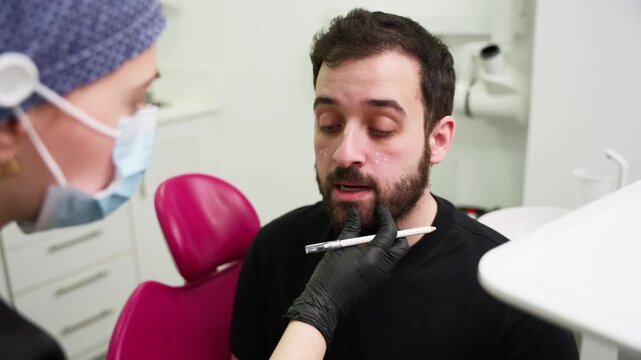 Cosmetologist injecting hyaluronic acid into man's face
