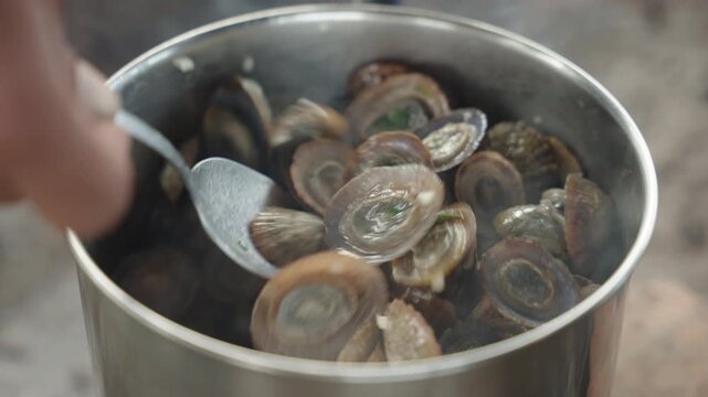 Cinematic Close-up of Lapas Limpets Being Cooked in a Pot with Garlic and Herbs, Traditional Azorean Cuisine, Flores Island