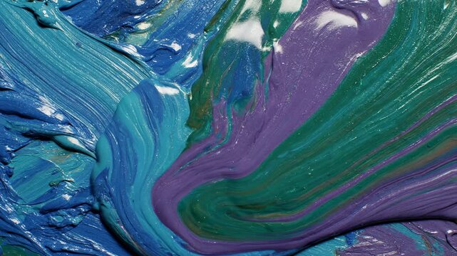 Viscose texture of vibrant blue, deep purple, and emerald green oil paints swirls and blends together, revealing thick impasto strokes and artistic fluidity in a rich, abstract macro view