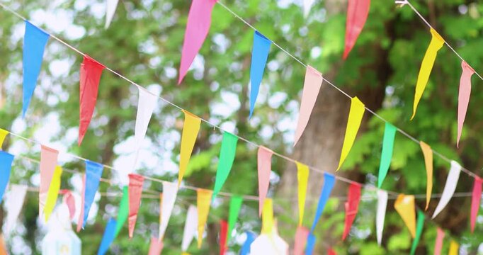 Colorful pennant flags hanging outdoors, gently swaying to create a festive, cheerful atmosphere. Perfect for celebrations, parties, and outdoor events