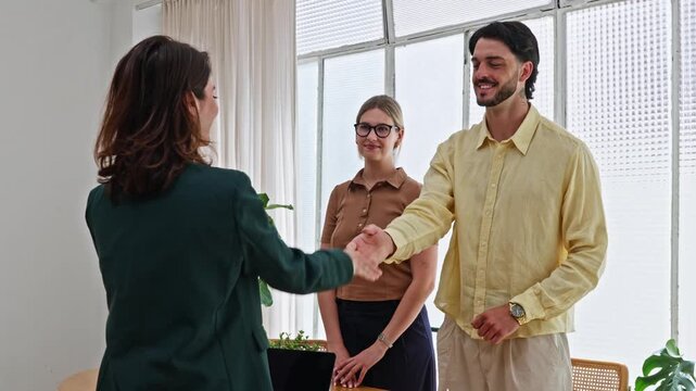 Real estate agent giving house keys to young couple