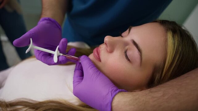 Cosmetologist performing hyaluronic acid injection for lip augmentation