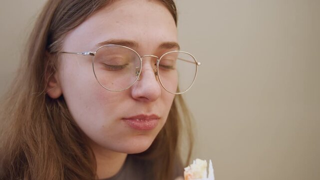 Young woman tasting spoonful, grimacing at sour flavor in closeup bespectacled sitter samples spoonful indoors, subtle lighting, kitchen test vibe, candid facial aversion and pucker, natural emotion