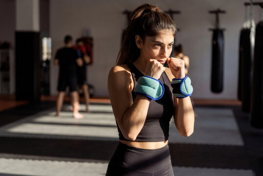 Athletic woman working out and practicing shadow boxing wearing wrist weights