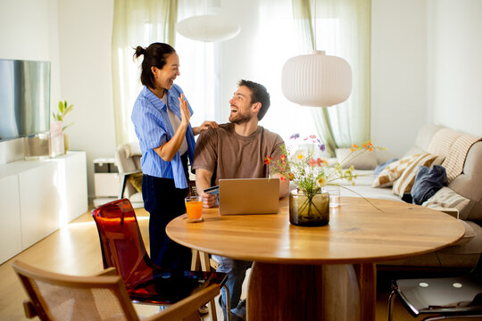 Couple shares a fun moment at home while working and enjoying time together in the kitchen