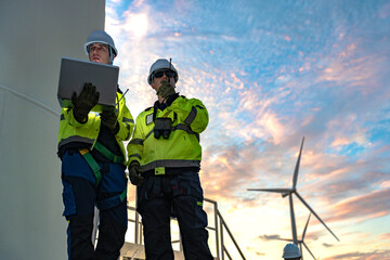 Green collar workforce using advanced tech to manage sustainable wind power. Visionary male engineers committed to global ESG goals under a colorful sunset. © ultramansk