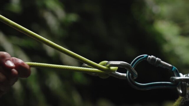 Cinematic Close-up of a Hand Holding a Climbing Rope Attached to a Carabiner, Canyoning or Rock Climbing Adventure