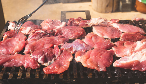 Tasty and juicy raw pork meat on charcoal grill.