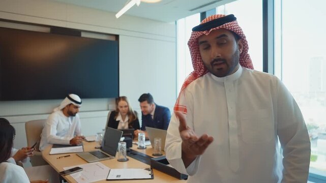 Saudi businessman talking to the business partners via video call in his office