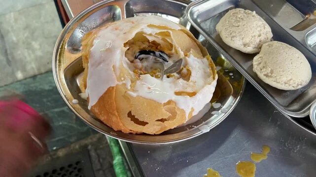 Traditional Raj Kachori prepared in a restaurant in India; professional food photography of a royal Indian street food chaat platter served in a contemporary, casual dining setting.