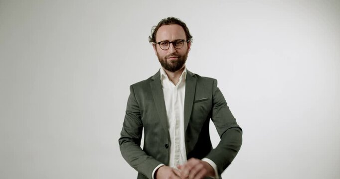 A businessman in a suit and glasses adjusts his shirt cuff. He looks directly at the camera with a serious expression. This is perfect for projects related to business, fashion, or getting ready.