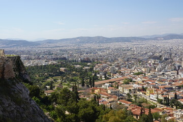 Obraz premium A panoramic view of the city of Athens, Greece, taken from the rock of the Acropolis, showing some of the neoclassical houses of the Plaka district and the dense urban fabric of the modern city