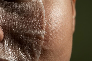 Naklejka premium Macro Detail of Moist Fabric Sheet Mask Applied to Human Face Skin